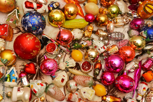 Christmas tree glass ornaments background. A close-up of a Christmas multi colored old and new baubles  animal  fairy tale and small houses ornaments ready to decorate a fir tree.