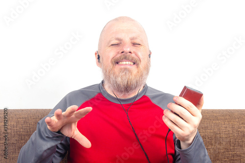 bearded man enjoys listening to his favorite music through an audio player in small headphones. audiophile and music lover. music and hi-fi sound.