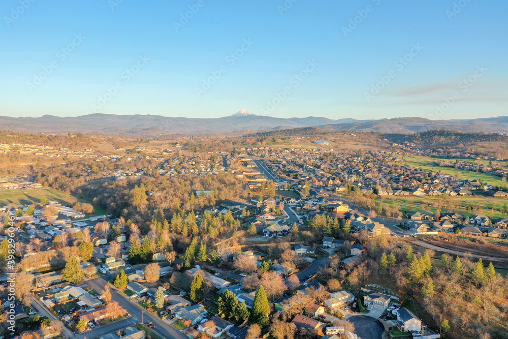 Peaceful town surrounded by trees with mountains as background