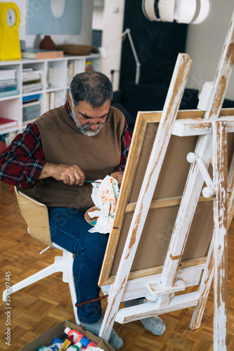 senior man painting at his home