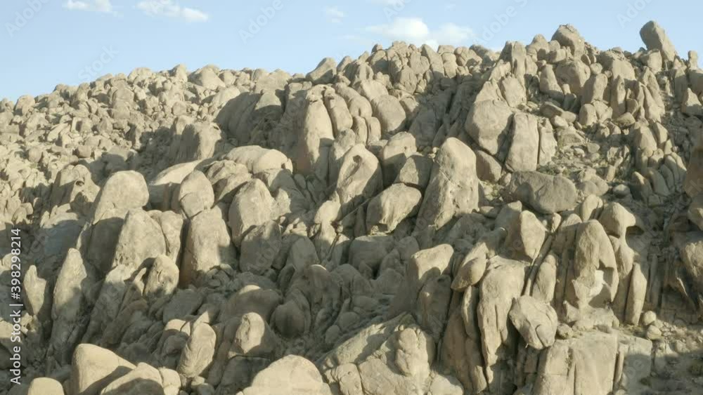 Flight over the giant rock formations of California's Alabama Hills with the city of Lone Pine in the background.