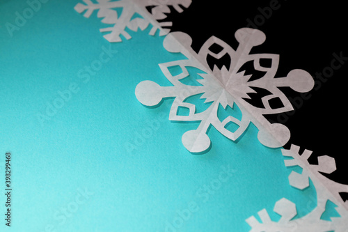 Paper handmade snowflake on blue background, copy space