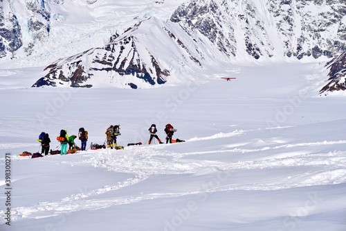 Mountain Climbers Watching a Plane Take Off from the Kahiltna Glacier photo