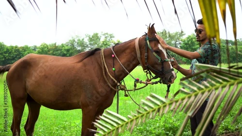 Young handsome man with brown horse. photo