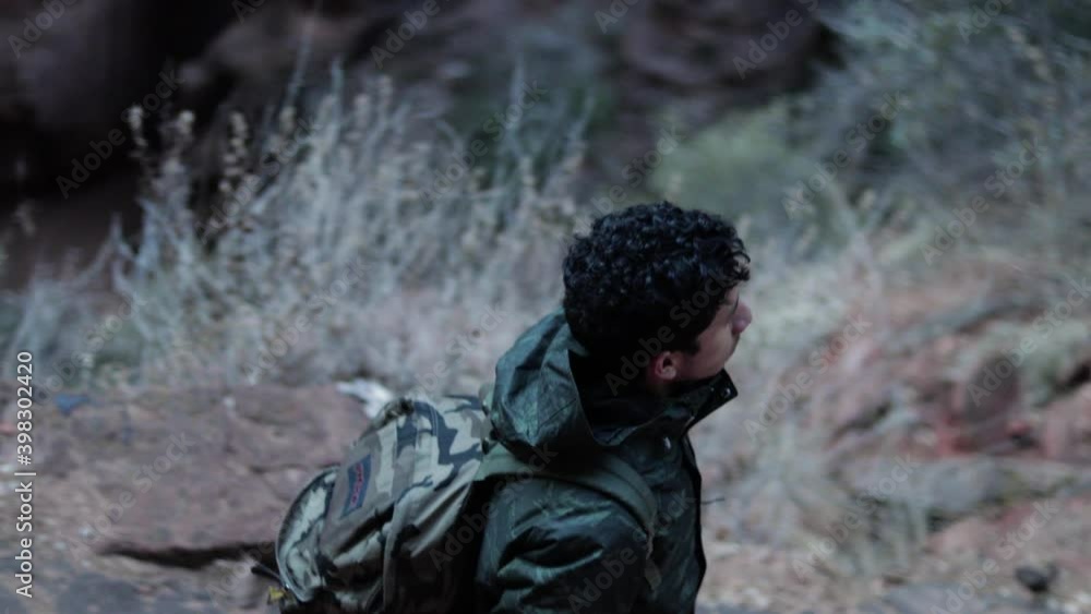 high angle of man hiking down a mountain high angle of man hiking down a mountain