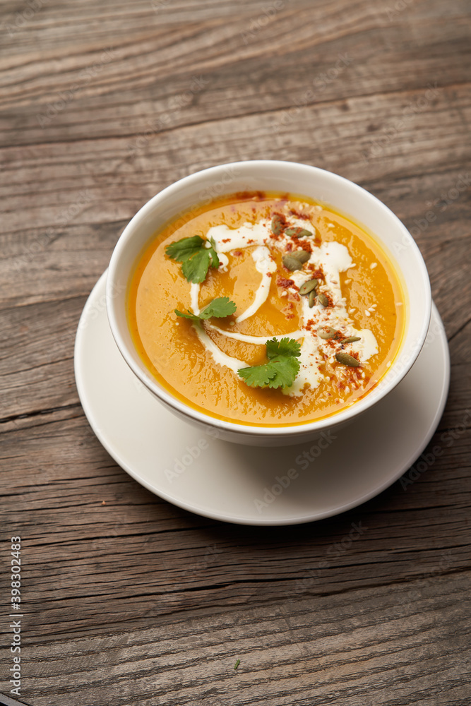 Pumpkin soup on a wooden table. Pumpkin soup puree Pumpkin soup on a wooden table. Pumpkin soup puree