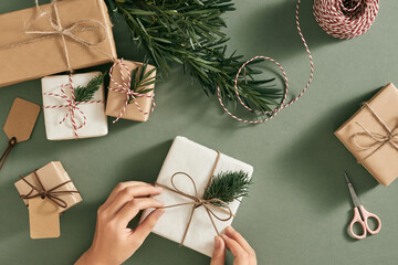 Female hands decorating presents at Christmas. Christmas concept.
