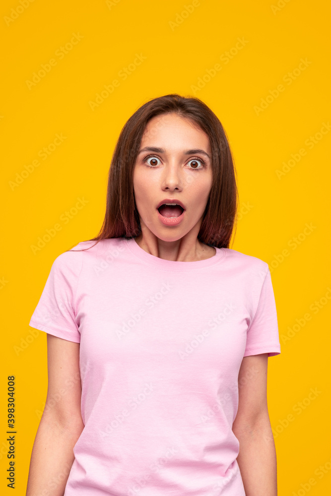 Fototapeta premium Shocked woman with mouth opened looking at camera