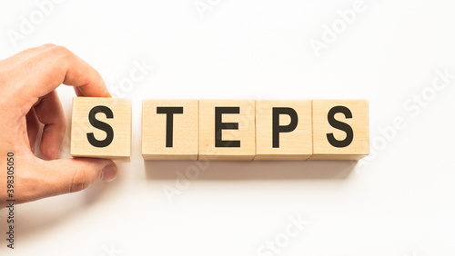 Word steps. Wooden small cubes with letters isolated on white background with copy space available.Business Concept image.