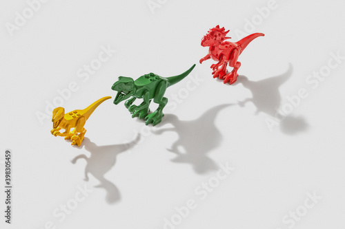 Three colored dinosaurs with shadows. photo