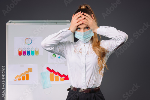 Businesswoman in a medical mask holds her head having a severe headache. Conference and pandemic. photo