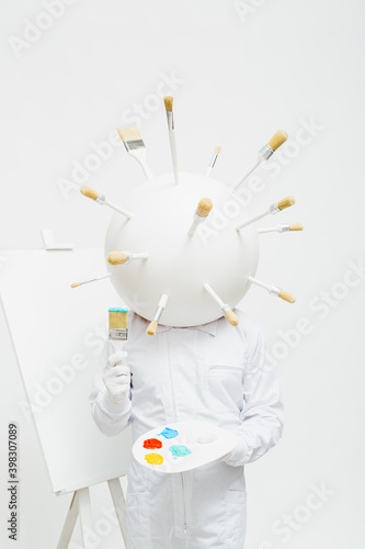 Artistic character with a big round head full of brushes working in his work. photo