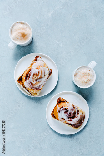 Two Cinnamon Buns with Capuccinos photo