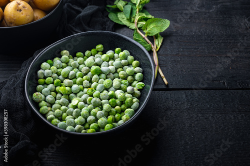 Green peas, on black wooden background with copy space