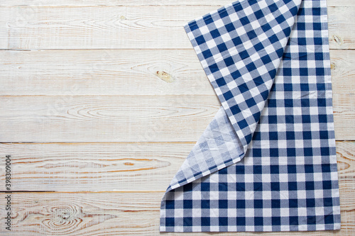 Checkered tablecloth on wooden table top view copy space