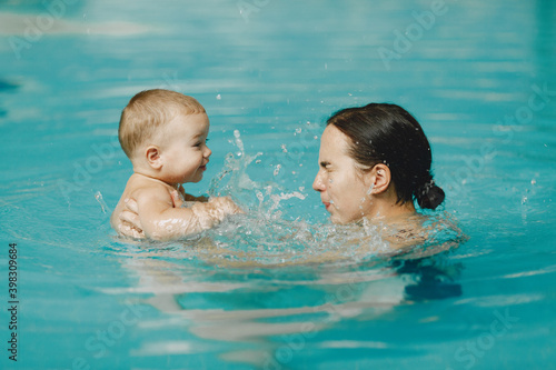 Little cute baby boy. Mother with son. Family playing in a water.