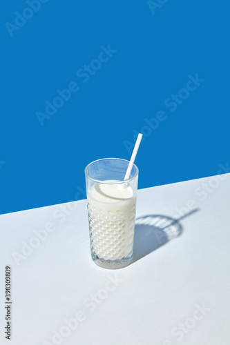 Glass of fresh natural milk with paper straw. photo