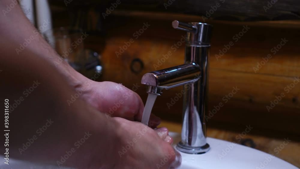 Man washing his hands in bathroom, macro shot of water on hands Man washing his hands in bathroom, macro shot of water on hands