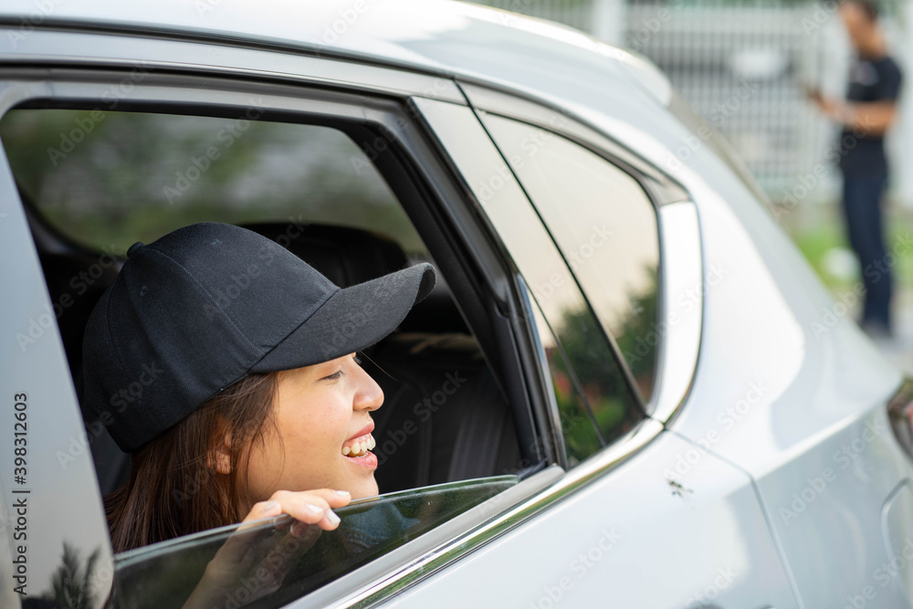 Asian young woman wearing hat in the vehicle traveling on holiday looking out of car window open. Asian young woman wearing hat in the vehicle traveling on holiday looking out of car window open.
