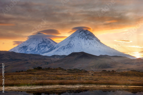 Sunset landscape with snowy tops of active volcanoes on Kamchatka.