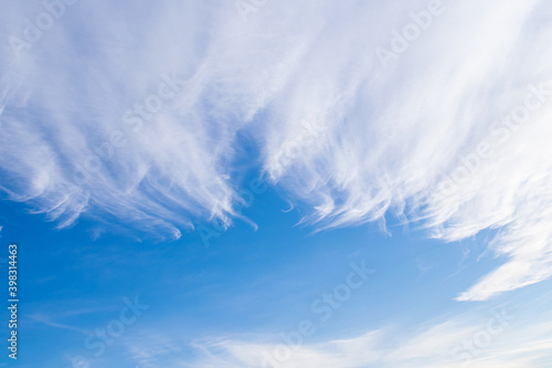 Beautiful white cirrus clouds against the blue sky. The clouds are very similar to bird feathers. Copy space. Blue sky in the background.