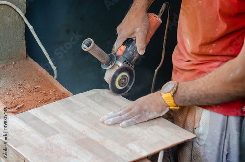 dark Latino man using a machine to cut pottery. construction work machine on a cut ceramic