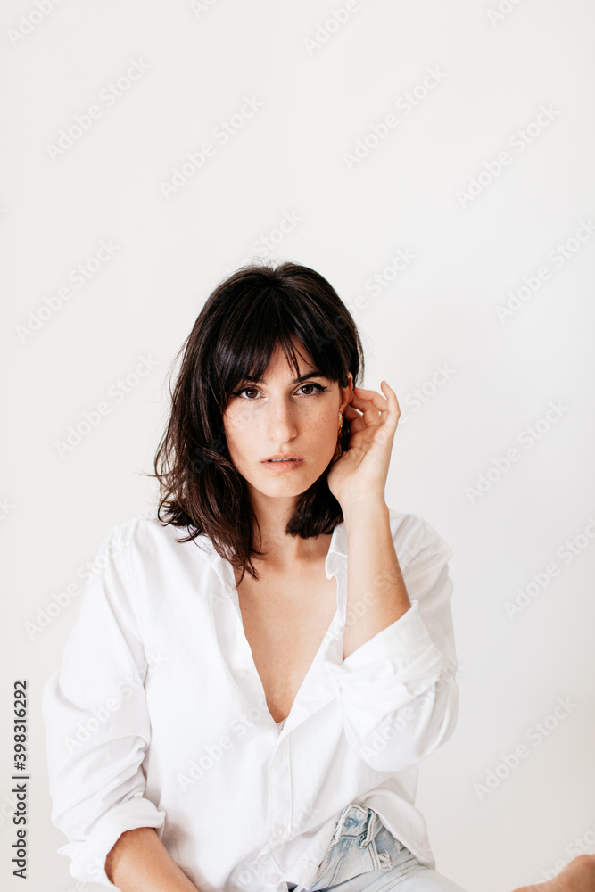 portrait of brunette young woman posing in studio with natural light portrait of brunette young woman posing in studio with natural light