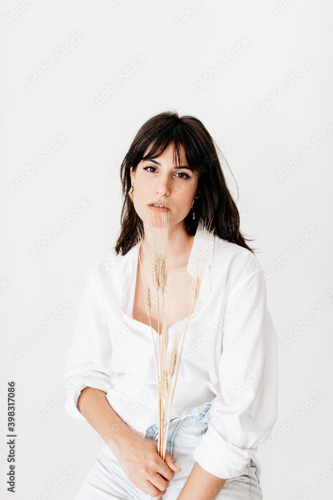 portrait of brunette young woman posing in studio with natural light portrait of brunette young woman posing in studio with natural light