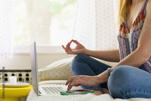 Woman Practicing Meditation on Bed at Laptop