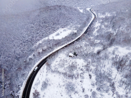High angle aerial view drone image on the road trough the trees and forest in mountain range covered with white snow in winter day near Knjazevac in Serbia - Travel journey and vacation concept © Miljan Živković
