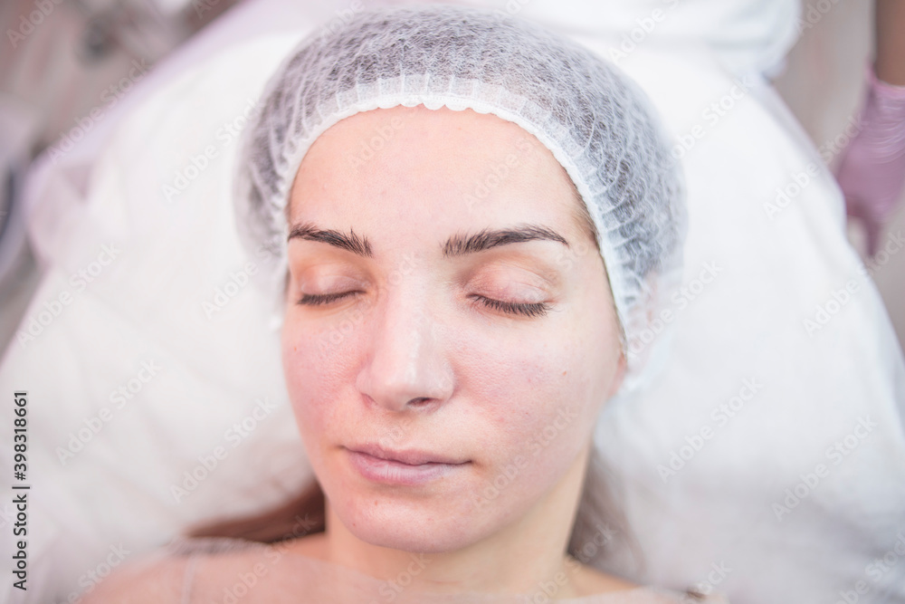 
Beautician makes facial cleansing for a girl in the salon