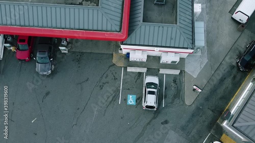 2-2 aerial hold over fastfood drive thru next to a gas station with 8 pumps and 2 outdoor retail ice box storages with an intigrated store within the gas station that selss prepackaged goods donuts photo