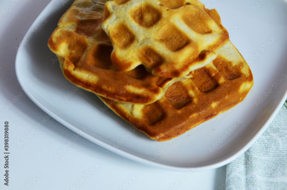 Homemade Belgium Waffles with fresh blueberries for breakfast. White plate, Viennese waffles with raspberries and mint. quick delicious breakfast on white background Homemade Belgium Waffles with fresh blueberries for breakfast. White plate, Viennese waffles with raspberries and mint. quick delicious breakfast on white background