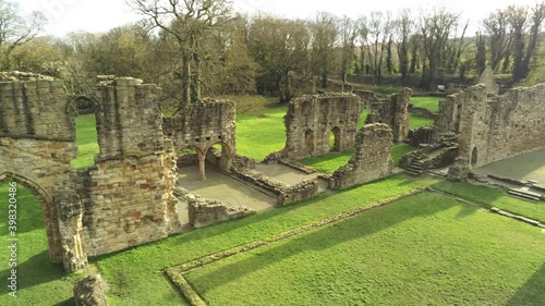 Basingwerk abbey landmark medieval abandoned Welsh ruins Aerial view right pan low angle photo