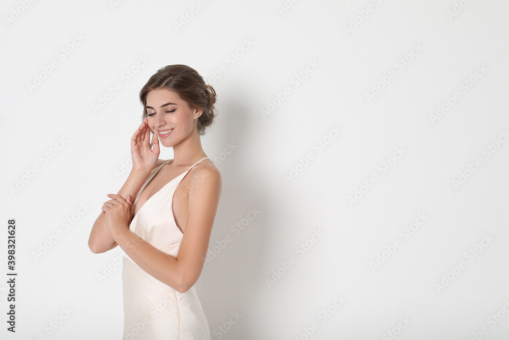 Young bride wearing beautiful wedding dress on light background. Space for text Young bride wearing beautiful wedding dress on light background. Space for text