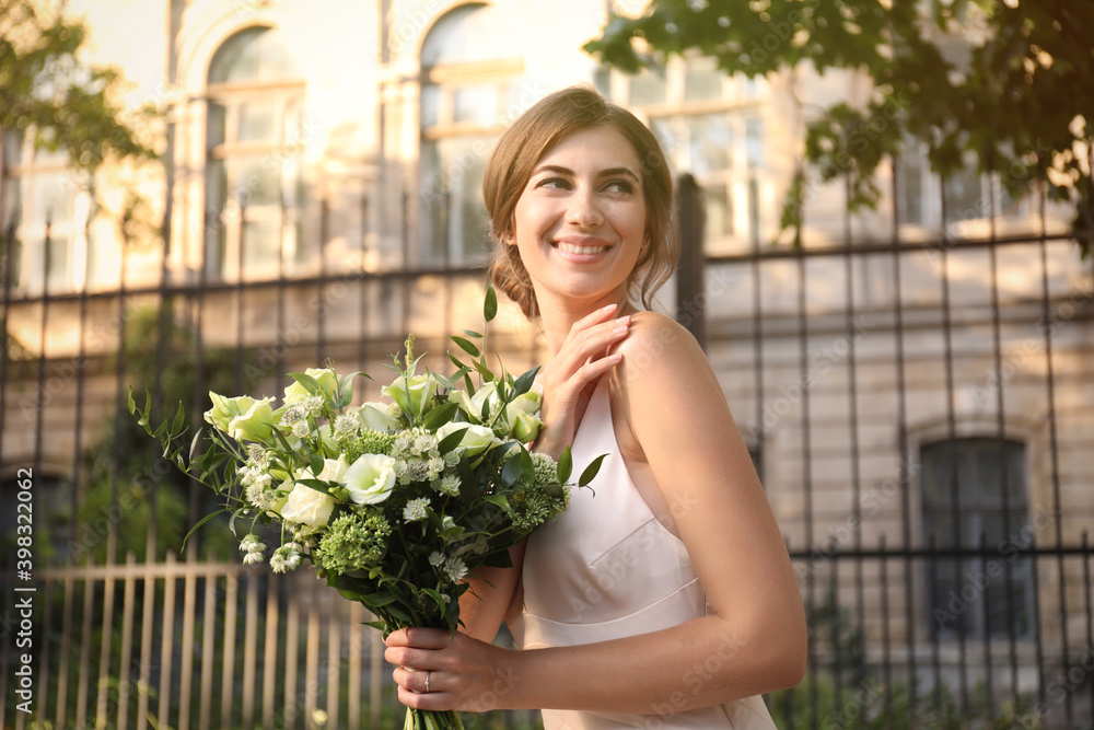 Gorgeous bride in beautiful wedding dress with bouquet outdoors Gorgeous bride in beautiful wedding dress with bouquet outdoors