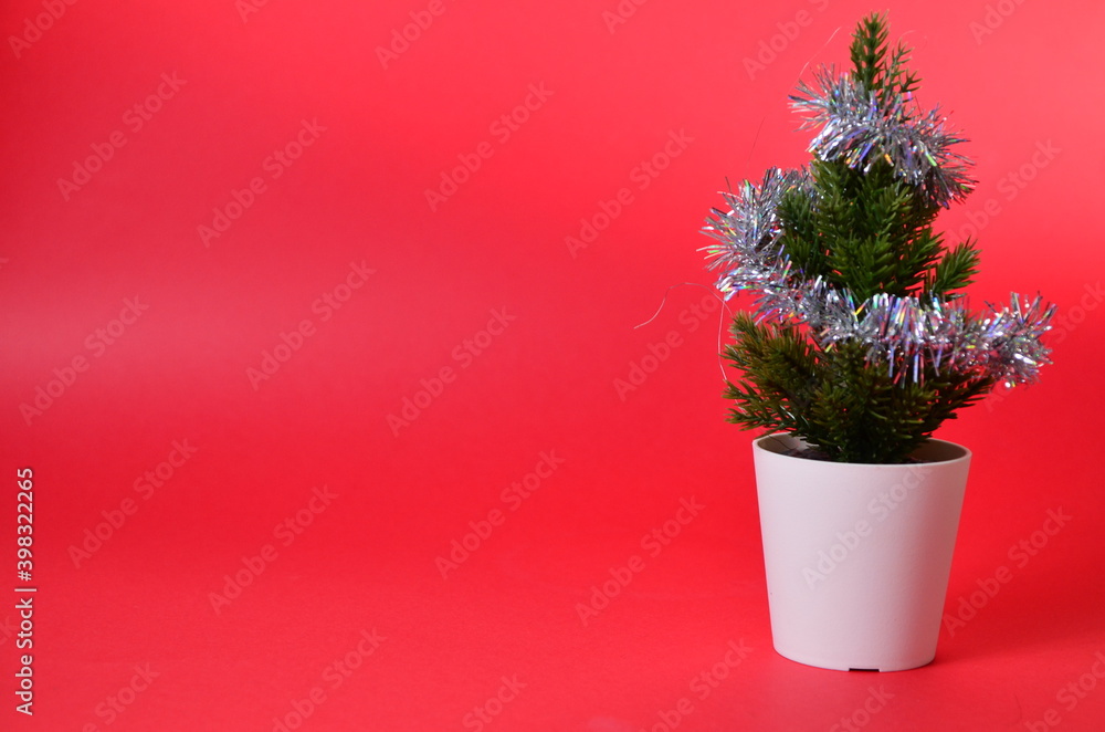 small Christmas tree decorations on red. Branches of a Christmas tree. Concept for Christmas or new year shopping. small Christmas tree decorations on red. Branches of a Christmas tree. Concept for Christmas or new year shopping.