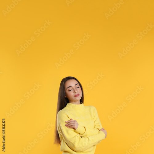 Beautiful young woman wearing warm sweater on yellow background. Space for text © New Africa