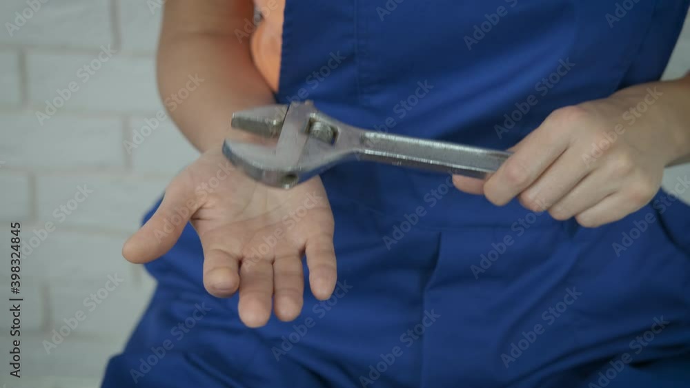 Hold a spanner in hands. Female hands with a large adjustable wrench. Hold a spanner in hands. Female hands with a large adjustable wrench.
