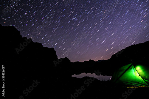 tent in the mountains at night with stars