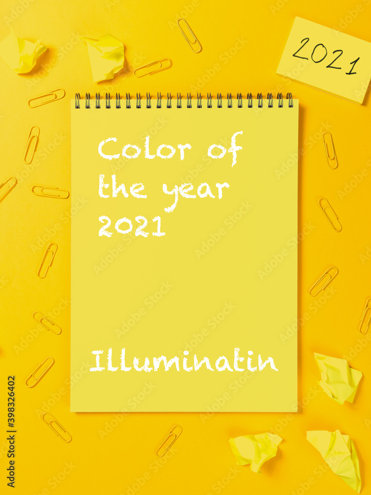 Notepad planner on trendy color of the 2021 year Illuminating yellow background. Office workspace with paper clip. Copy space for your text