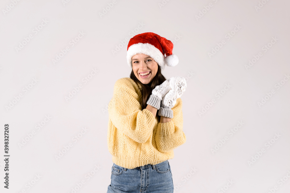 Winter, christmas concept. Smiling beautiful woman in red hat and white mittens standing smiling over white background Winter, christmas concept. Smiling beautiful woman in red hat and white mittens standing smiling over white background