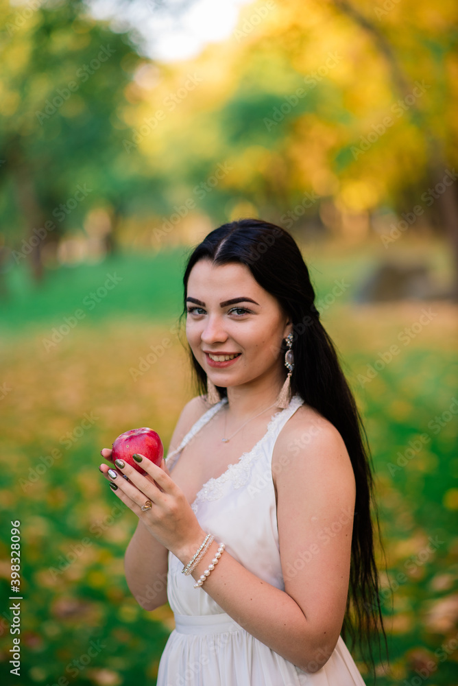 Beautiful brunette young female in white dress in autumn park Beautiful brunette young female in white dress in autumn park
