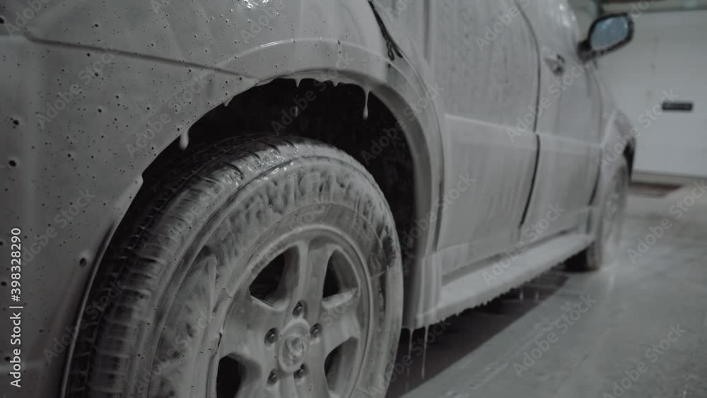 a man applies foam to a car at a car wash a man applies foam to a car at a car wash