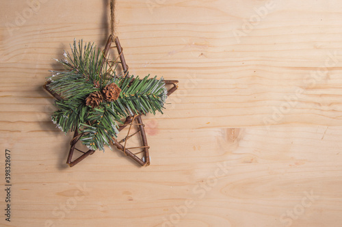 decorative wooden star, green tinsel and pine cones, isolated on wooden