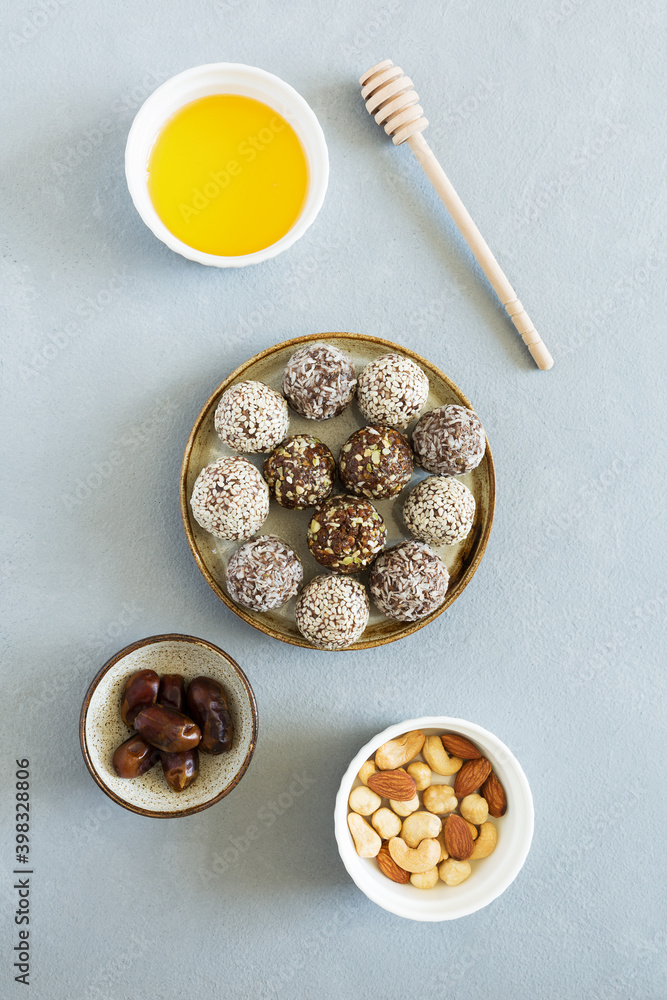 Sweet candy energy balls with nuts, dried fruits and honey on plate flat lay on light background. Vegetarian, organic food. Sweet candy energy balls with nuts, dried fruits and honey on plate flat lay on light background. Vegetarian, organic food.