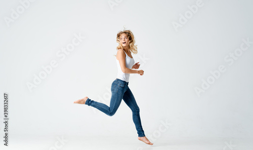 woman jumped up on a light background in full growth sport fitness 
