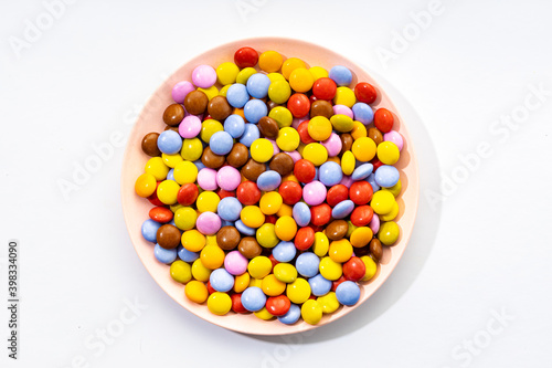 Multicolored Chocolate candy in plate on white background