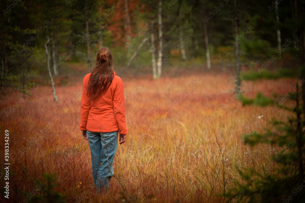 woman in a red meadow in the autumn forest