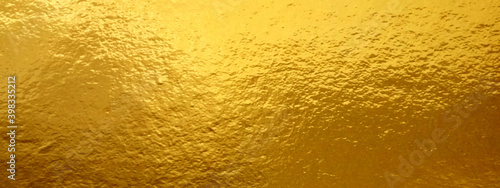 Gold foil texture background with highlights and uneven surface © Alrika 